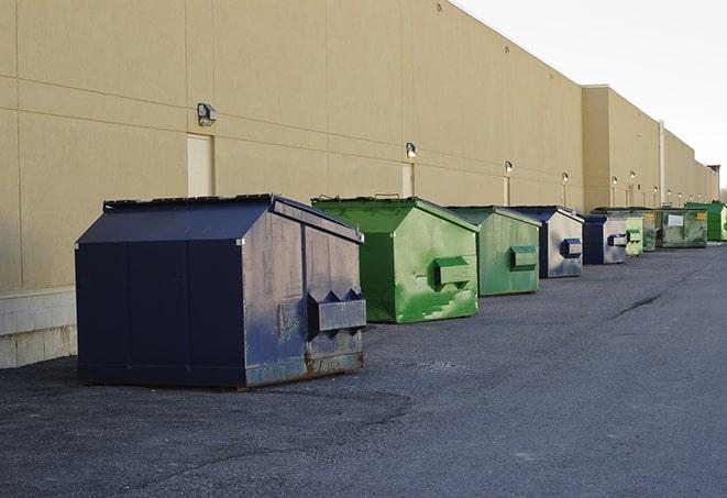 tilted front-load dumpsters being emptied by waste management workers in Newark